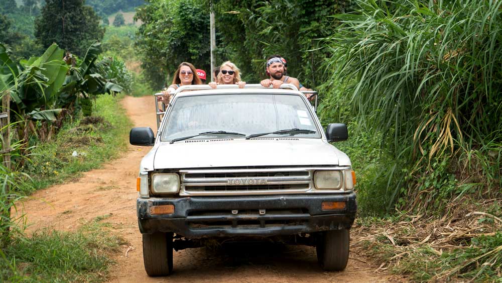 A group of visitors on an old Toyota pickup truck.